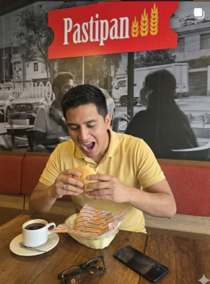 Pieza de Pastipan con un cliente disfrutando un sándwich en una tienda.